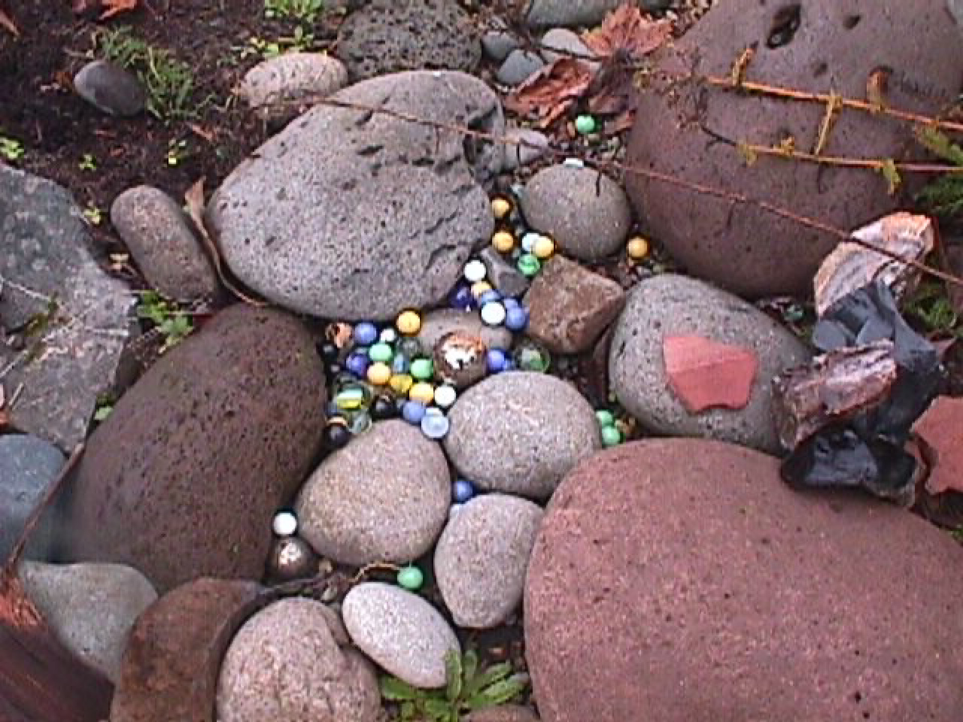 River rocks and a collection of marbles and agates in a stream-like pattern.