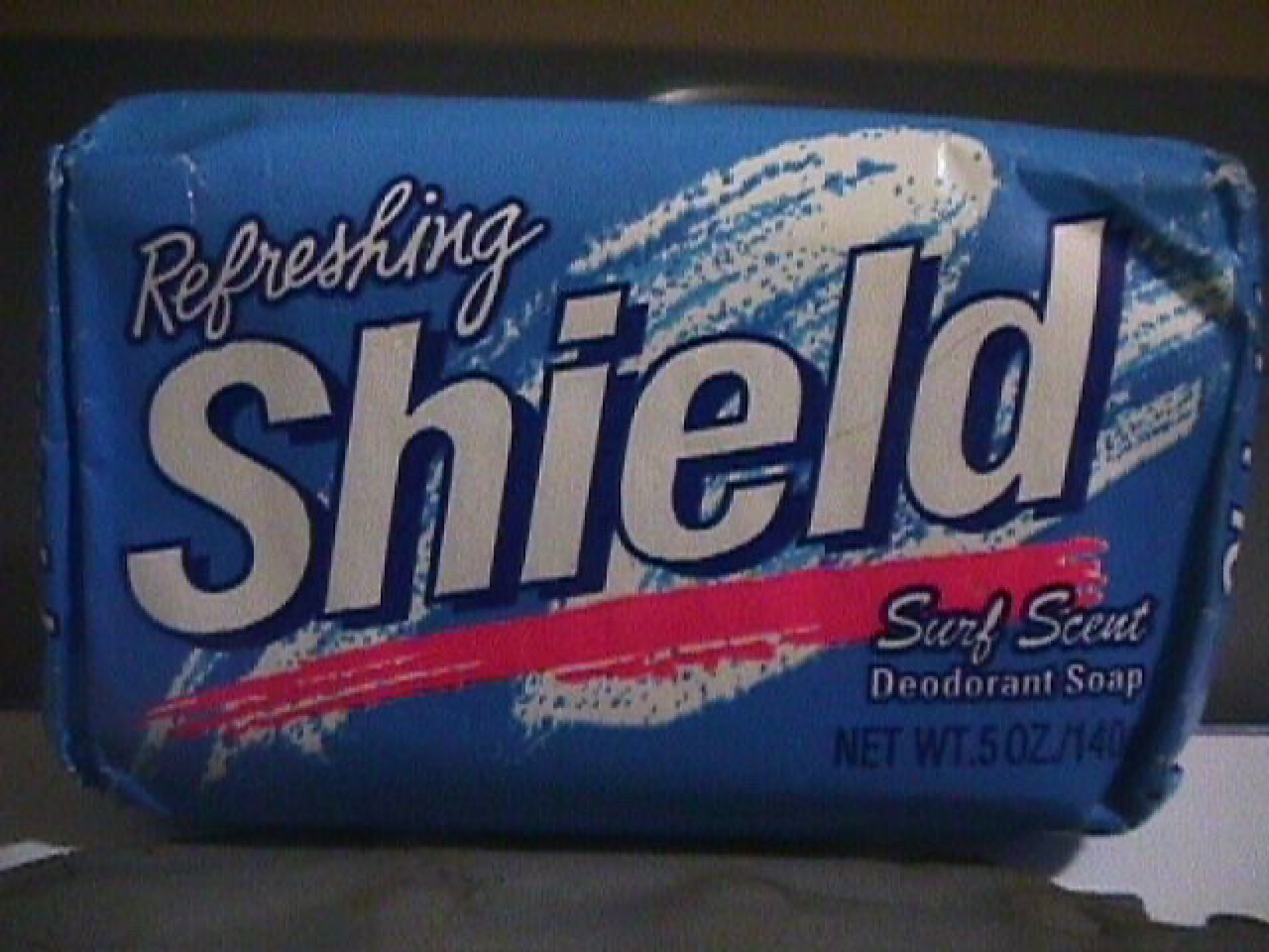 Shield soap with a blue wrapping and 90s pastel swipes in pink and white 