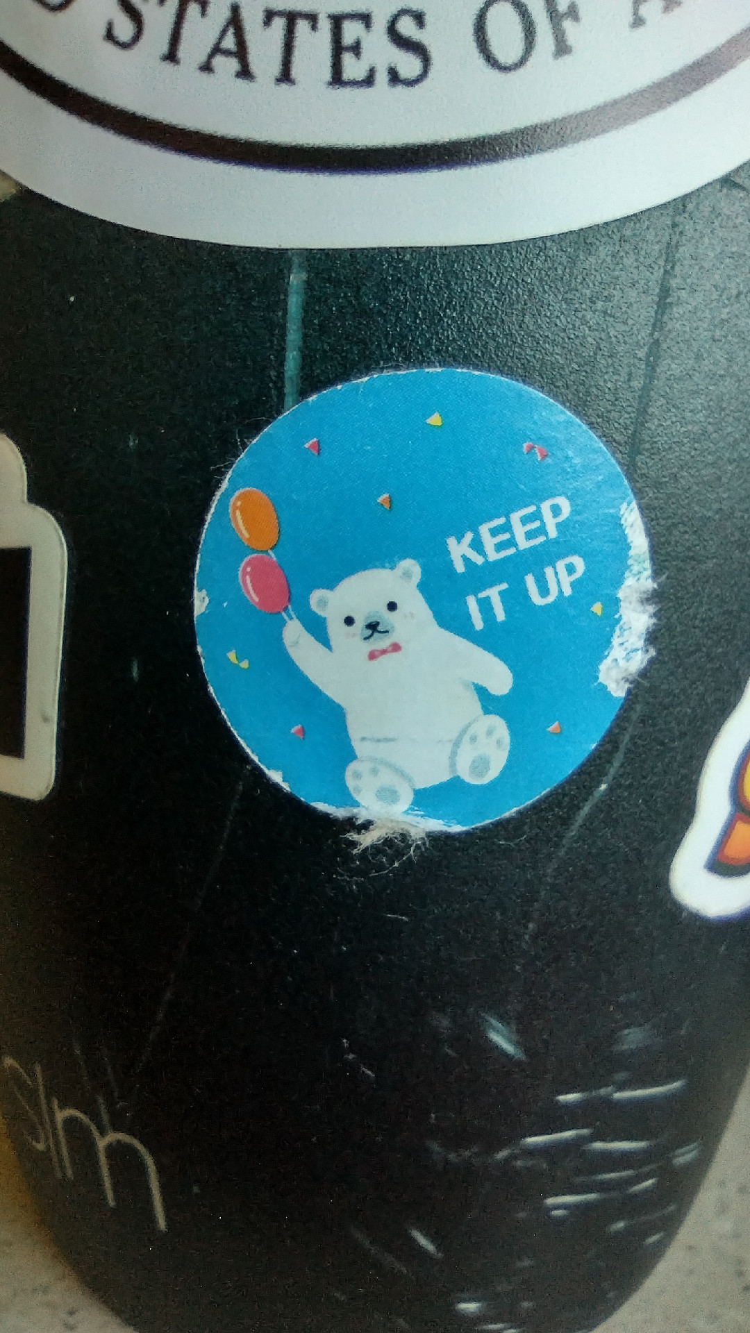 Worn sticker of a polar bear holding balloons that says Keep It Up