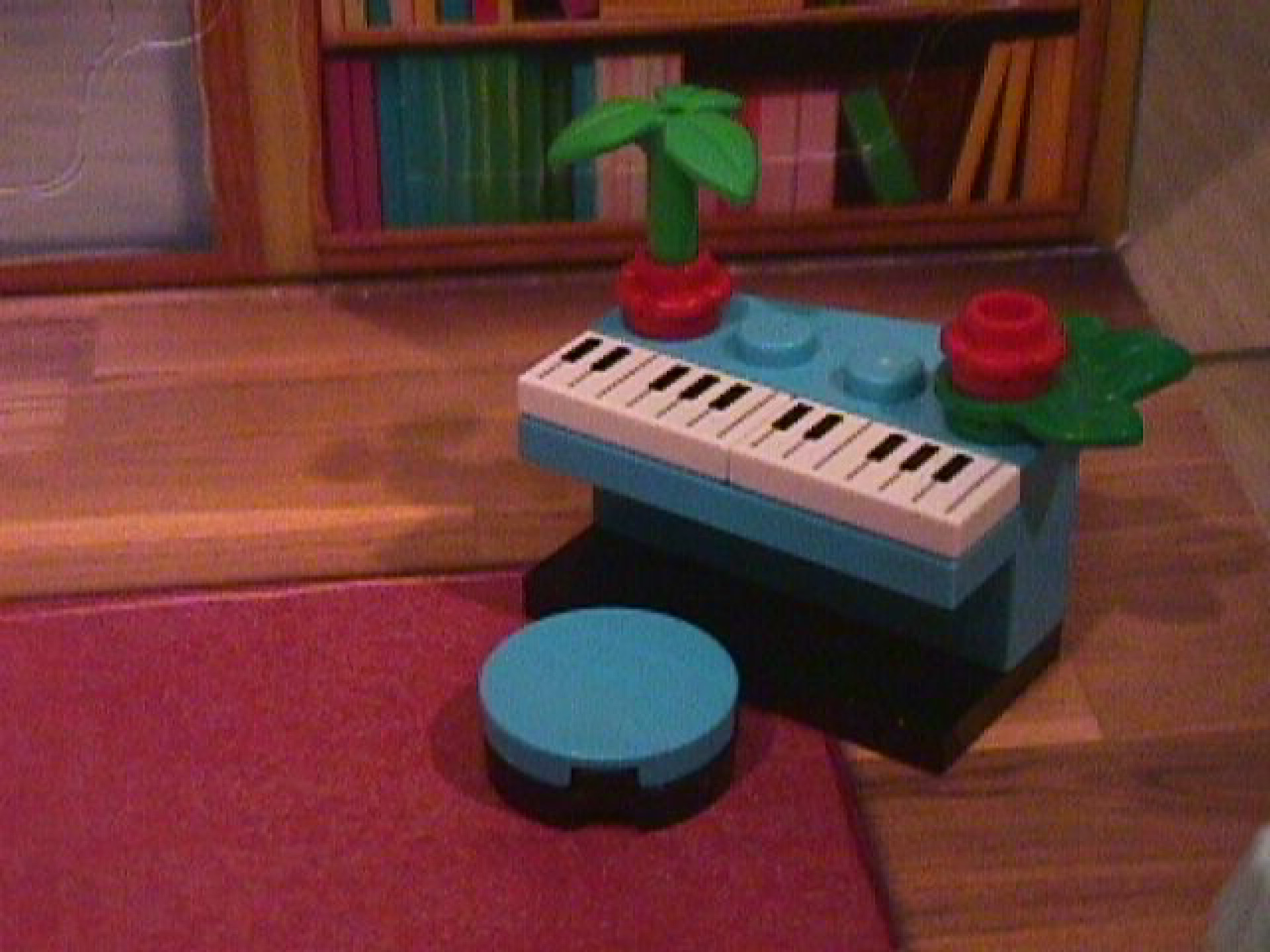 A LEGO piano from the 2024 Friends Advent calendar. The piano is blue with a blue cushion.