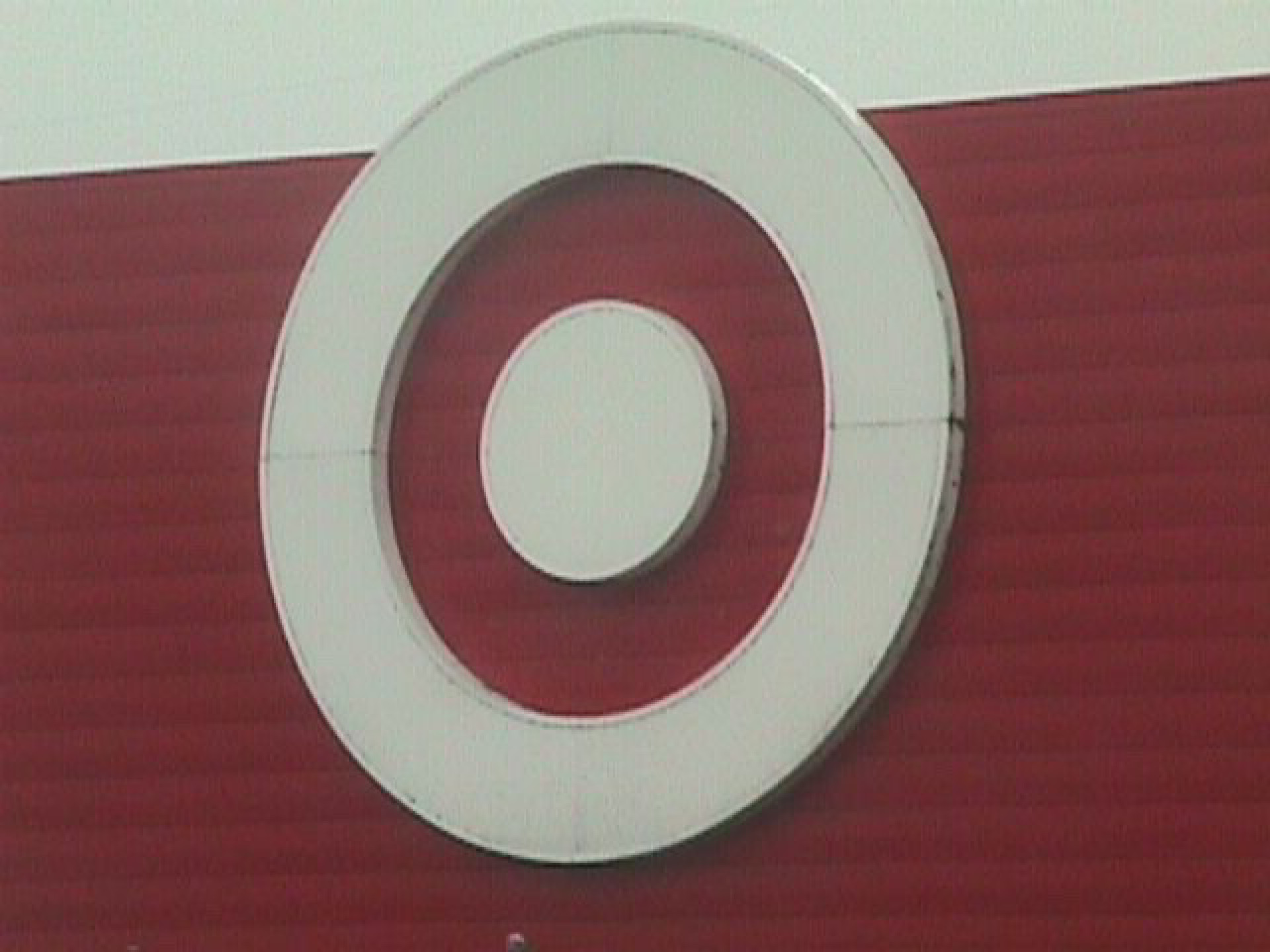 Bullseye target sign on red background under overcast sky 